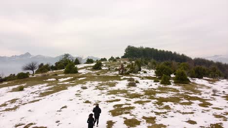 Athleten,-Die-Auf-Einem-Berg-Auf-Schnee-Im-Winter-Drohnenschuss-Laufen