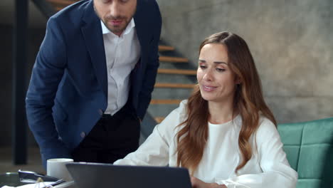 Porträt-Lächelnder-Kollegen,-Die-Am-Arbeitsplatz-Auf-Den-Laptop-Bildschirm-Schauen.-Büroarbeit