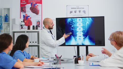 médico explicando las funciones de espín apuntando a la imagen digital de rayos x