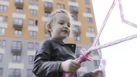 happy little girl blowing bubbles outside