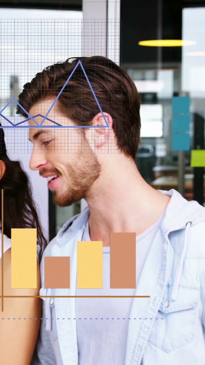 Video vertical: Hombre girando, sonriendo e inclinándose tras la señal de un colega con gráficos de negocios sobre cristal.