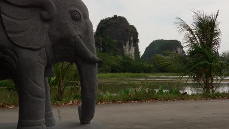 elephant statue in front of karst mountains and lake