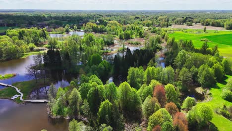 a picturesque region of karst lakes, lush forests, and a canoe-shaped observation tower in kirkilai, biržai regional park, lithuania - aerial drone shot