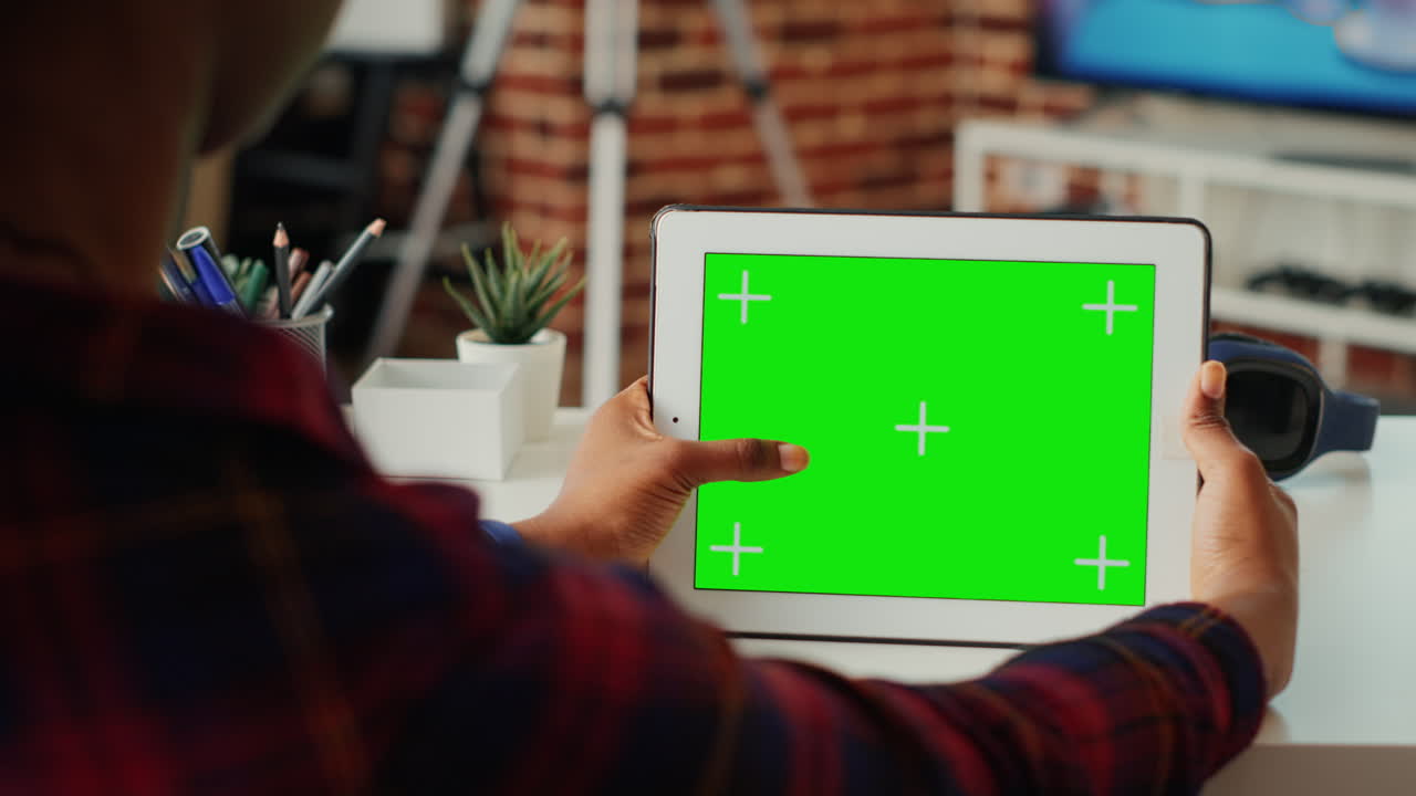 Female freelancer using horizontal greenscreen on wireless device