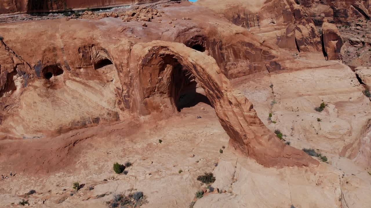 Una ripresa aerea con drone ad alta quota dell'Arco Corona, un enorme arco naturale di arenaria situato in un canyon laterale del fiume Colorado, appena a ovest di Moab, Utah