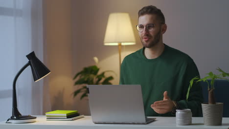 adult-man-is-conducting-webinar-talking-at-web-camera-of-laptop-blogger-or-specialist-is-lecturing-from-apartment-using-internet-connection