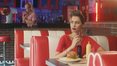 Pin-up-Mädchen,-Das-Eine-Cola-In-Einem-Amerikanischen-Diner-Trinkt