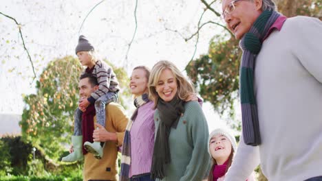 Vídeo-De-Padres-Caucásicos-Felices-Caminando-Con-Su-Hijo,-Su-Hija-Y-Sus-Abuelos-En-Un-Jardín-Soleado