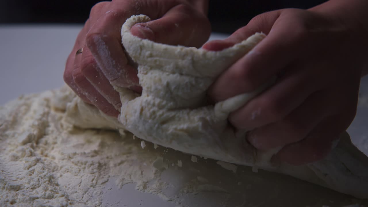 Primo piano di mani che impastano pasta fresca con la farina