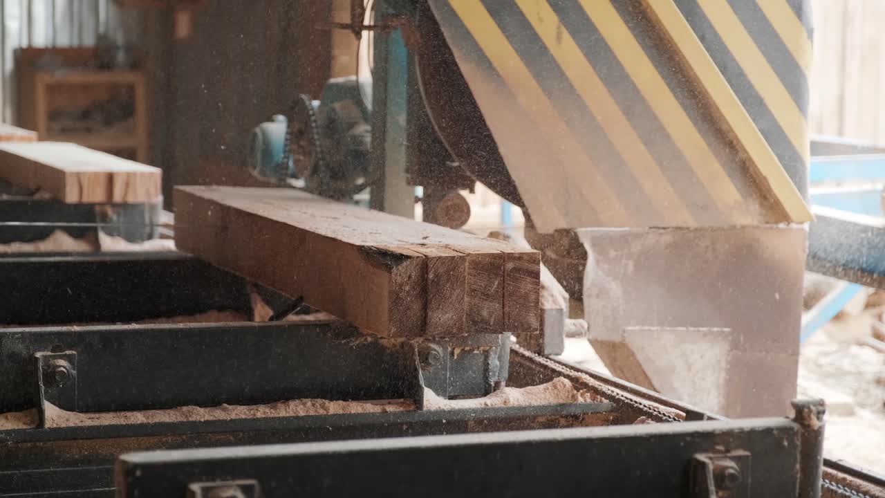 Sawing machine at wood production factory. Timber material processing and cutting at sawmill. Manufacturing process at lumber mill. Automatic Circular Sawing Machine