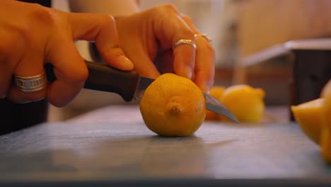 woman cutting lemon slices in a kitchen