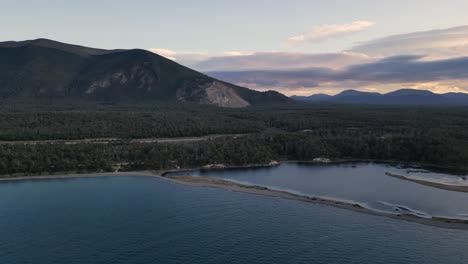 Filmischer-See-In-Patagonien,-Luftaufnahme-über-Dem-Blauen-Wasser-Von-Tolhuin,-Dem-Kiefernwald-Und-Dem-Andenkordillera-Gebirge-Bei-Tageslicht