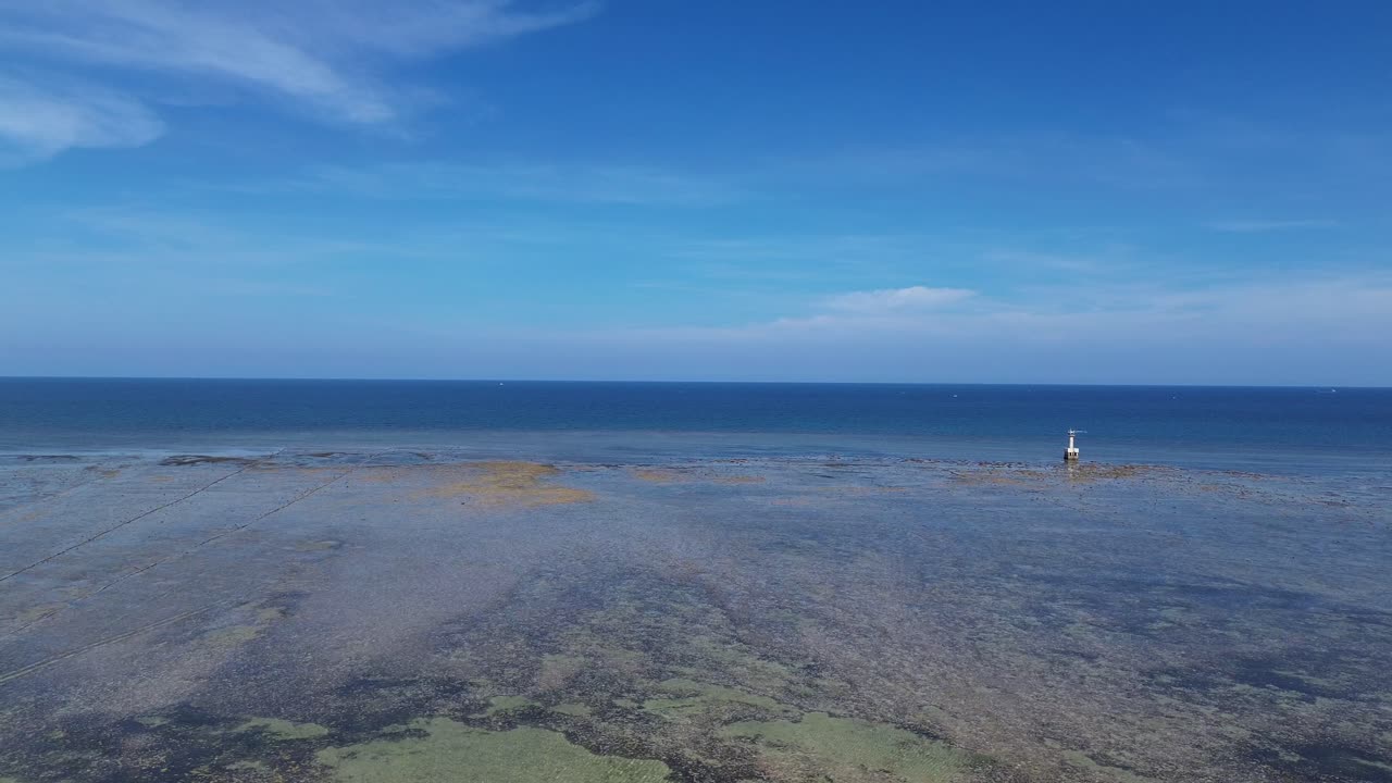 Drone shot with left pan showing the wide expanse of shallow waters and natural textures in My Hoa Lagoon, Phan Rang, Vietnam.