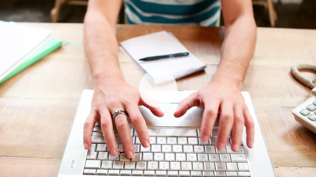 Man typing on laptop and initiating expanding network overlay while writing notes for tech task