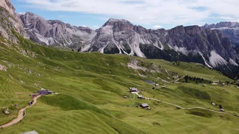 val gardena valley at south tyrol, italian alps, dolomites, italy - aerial drone view of tourists walking the hiking trail to the top of mount seceda