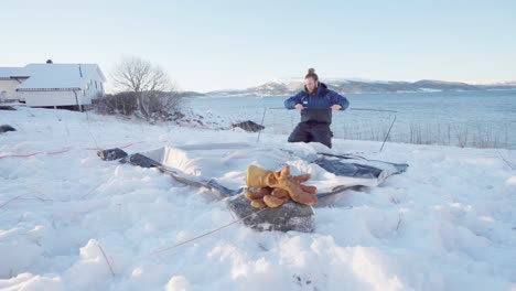 Mann,-Der-An-Einem-Kalten-Tag-Im-Winter-Ein-Campingzelt-Am-Fluss-Aufbaut