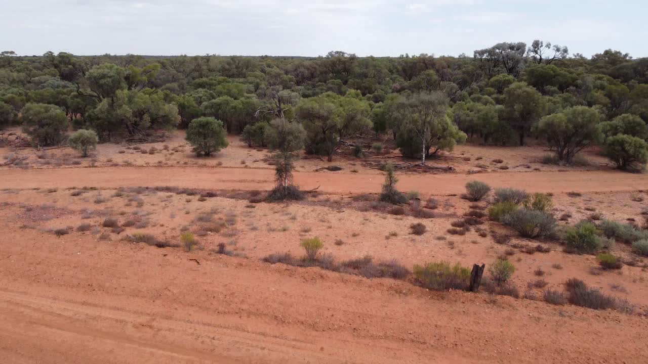 drone descendiendo en el interior de australia mostrando una carretera no sellada