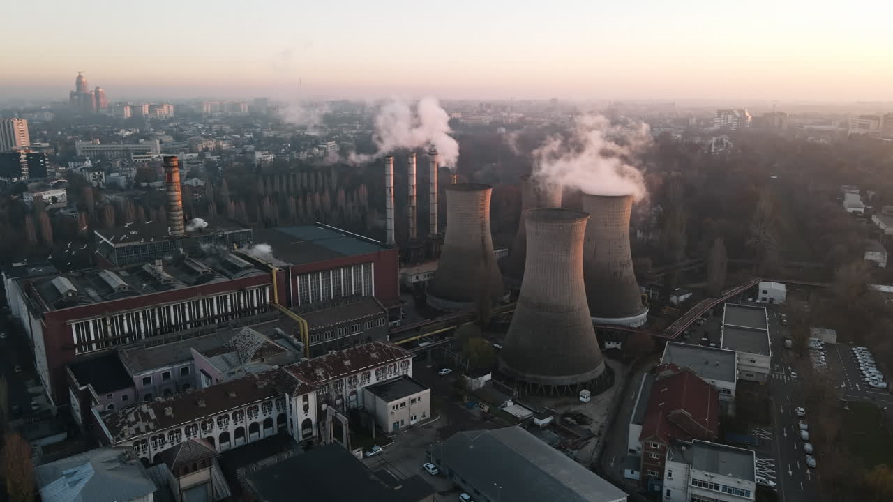 Power station with a lot of tubes and facilities in Bucharest, a lot of foam, buildings and church on the background. Cityscape, view from the drone, Romania