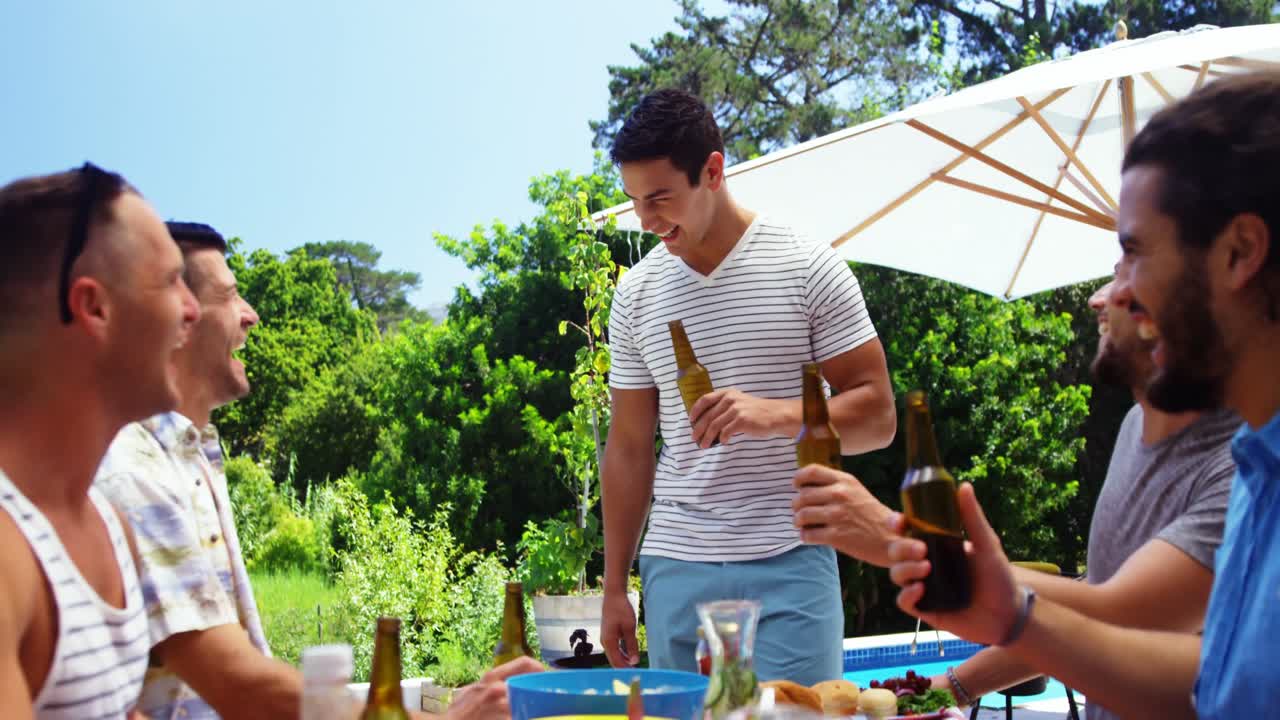 행복 한 친구 들 이 야외 바베큐 파티 에서 음료 를 즐기고 있다