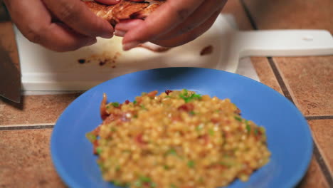 placing sliced, fried chicken breast on a bed of moist and savory bed of couscous for serving