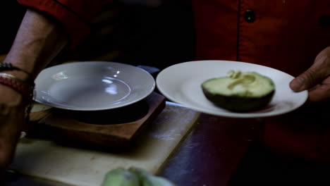 hombre poniendo aguacates en platos