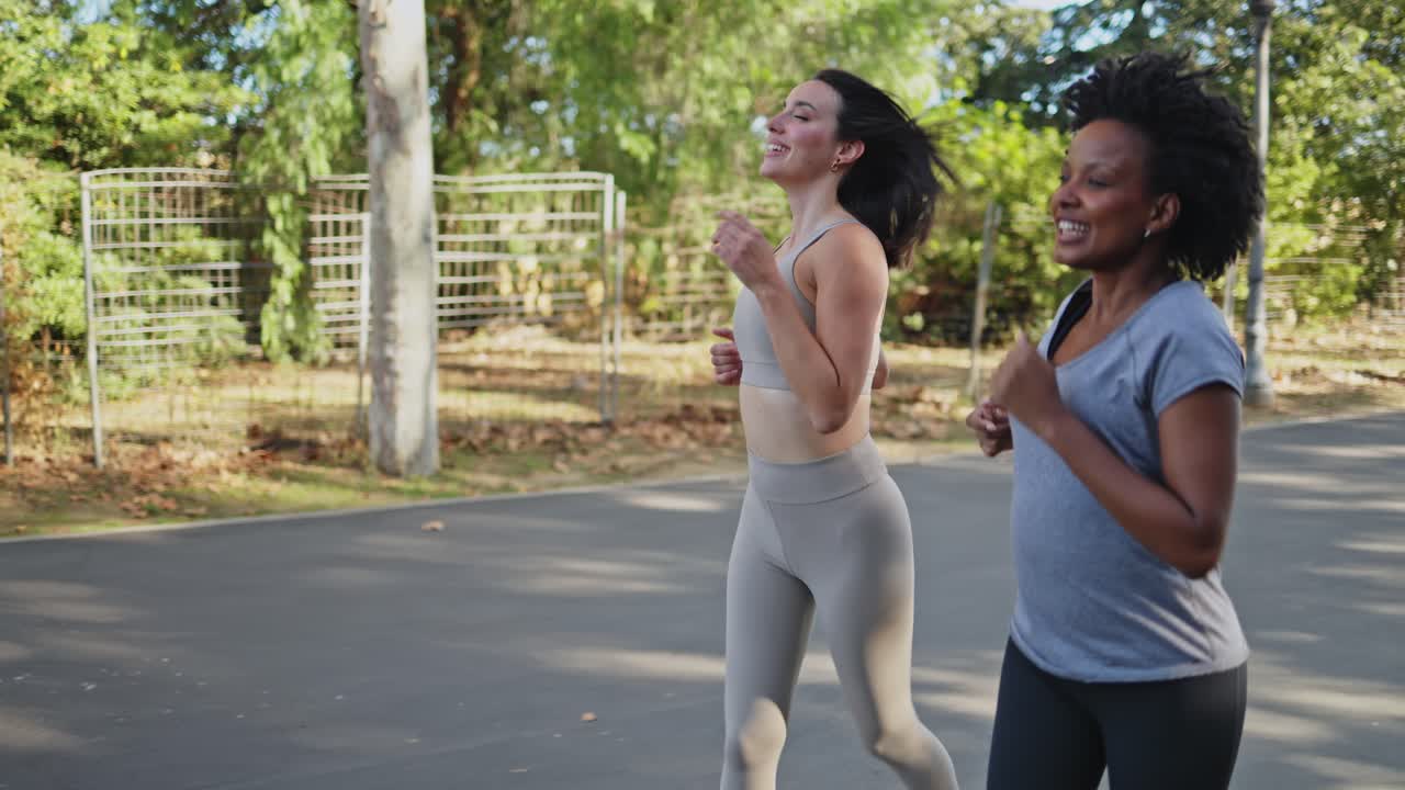 Due donne felici che corrono e parlano insieme in un parco