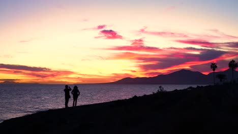 sunset over the ocean with people watching