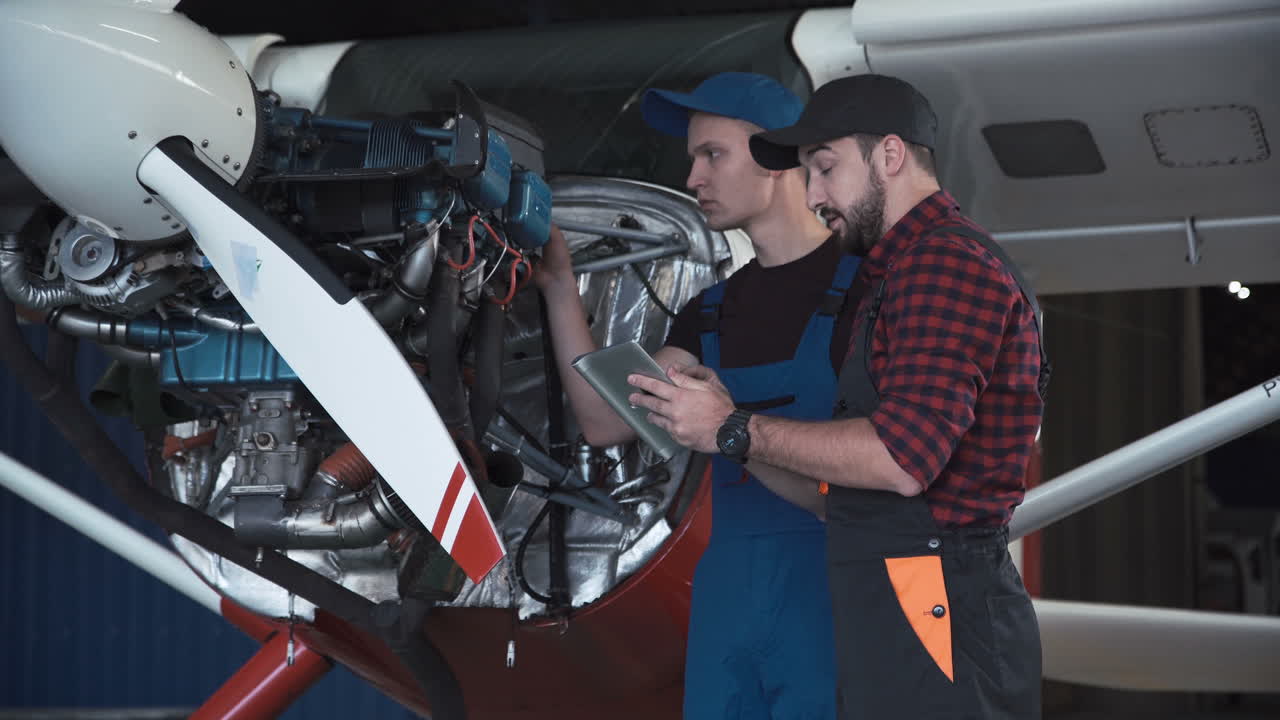 Airplane Mechanics Inspecting Engine