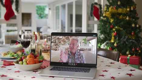 Glücklicher-Kaukasischer-älterer-Mann-Auf-Laptop,-Der-Auf-Dem-Weihnachtstisch-Liegt