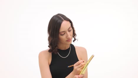 young woman thinking and writing in a notepad