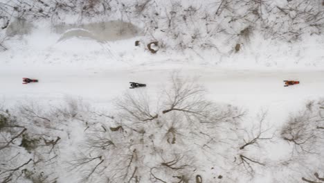 Schneemobile-Fahren-Entlang-Der-Schneebedeckten-Straße,-Luftaufnahme-Von-Oben-Nach-Unten