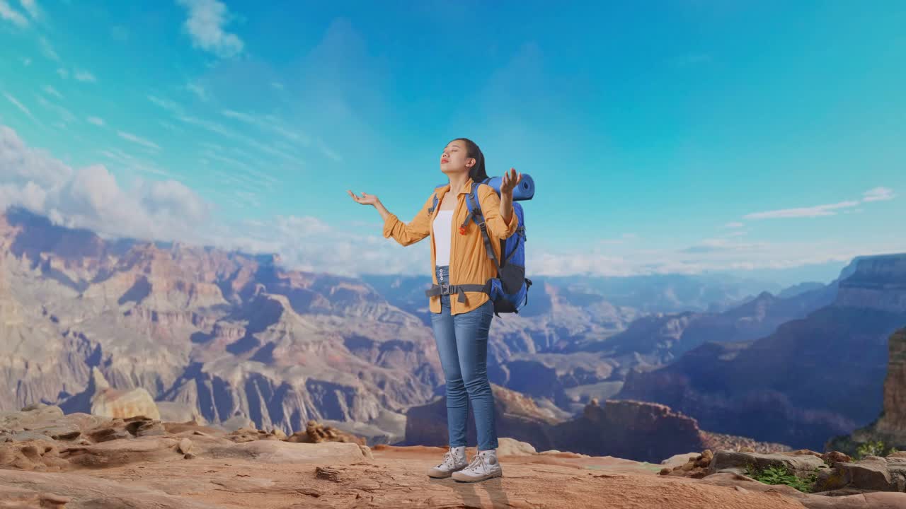 Full Body Side View Of Asian Female Hiker With Mountaineering Backpack Smiling And Spreading Arms Enjoy Looking The View Around While Traveling At The Top Of Mountain