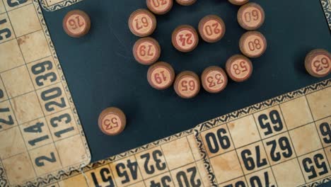 a close-up smooth zoom in rotating shot from above of a bingo wooden barrels in a circle, woody figures, old numbers background, vintage board game, professional lighting, slow motion 120 fps