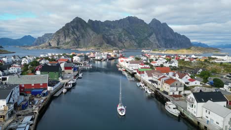 boat sails in henningsvaer harbour, lofoten island, norway, scandinavia - 4k aerial