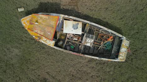 Derelict-boat-wreck-abandoned-on-marshland,-rise-up-reveal