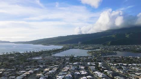 slow moving aerial dolly of hawaii kai city in honolulu hawaii with bright skies and fluffy white clouds