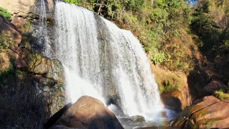 Drone-aerial-shot-of-a-inspiring-tropical-waterfall-In-Brazil-slowly-revealed-behind-a-rock