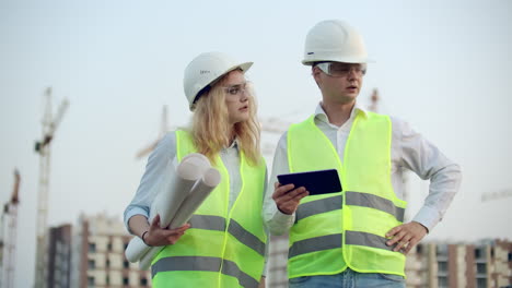 El-Gerente-De-Construcción-Y-El-Ingeniero-Caminan-Trabajando-En-El-Sitio-De-Construcción-Usando-Tabletas-E-Impresiones.