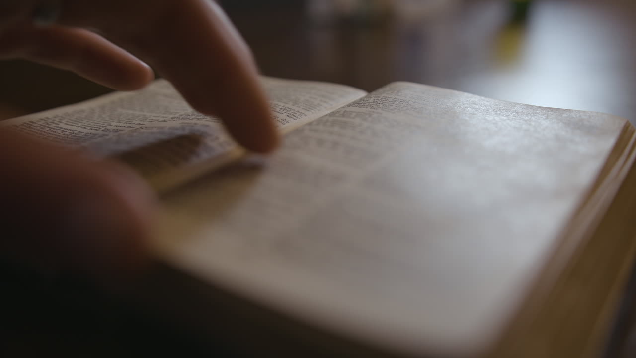 primer plano de una biblia que se coloca sobre una mesa y páginas que se hojean