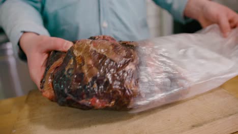 View-of-a-man-unpacking-frozen-steak-loft-in-a-close-up-view