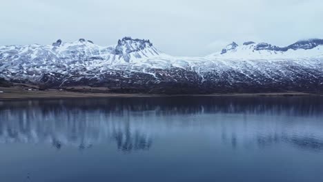 Snowy-rocky-mountains-at-lakeside-on-winter-day