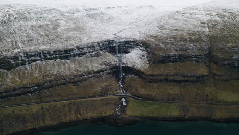 Faroe Islands, 4K Aerial wide pull back and tilt up of beautiful Foss&aacute; waterfall