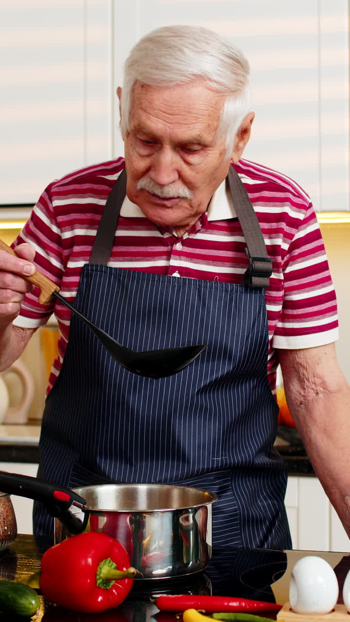 Großvater kocht hausgemachte Suppe in der heimischen Küche, probiert gesunde Mahlzeit für Diätplan zum Abnehmen.