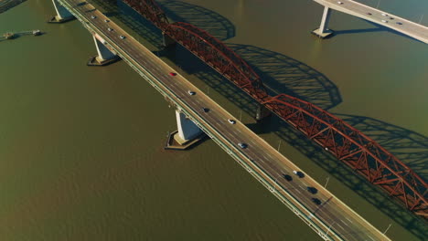 automobile and railway bridges over california bay, usa. three martinez bridges over the dark water on sunny day. top view.