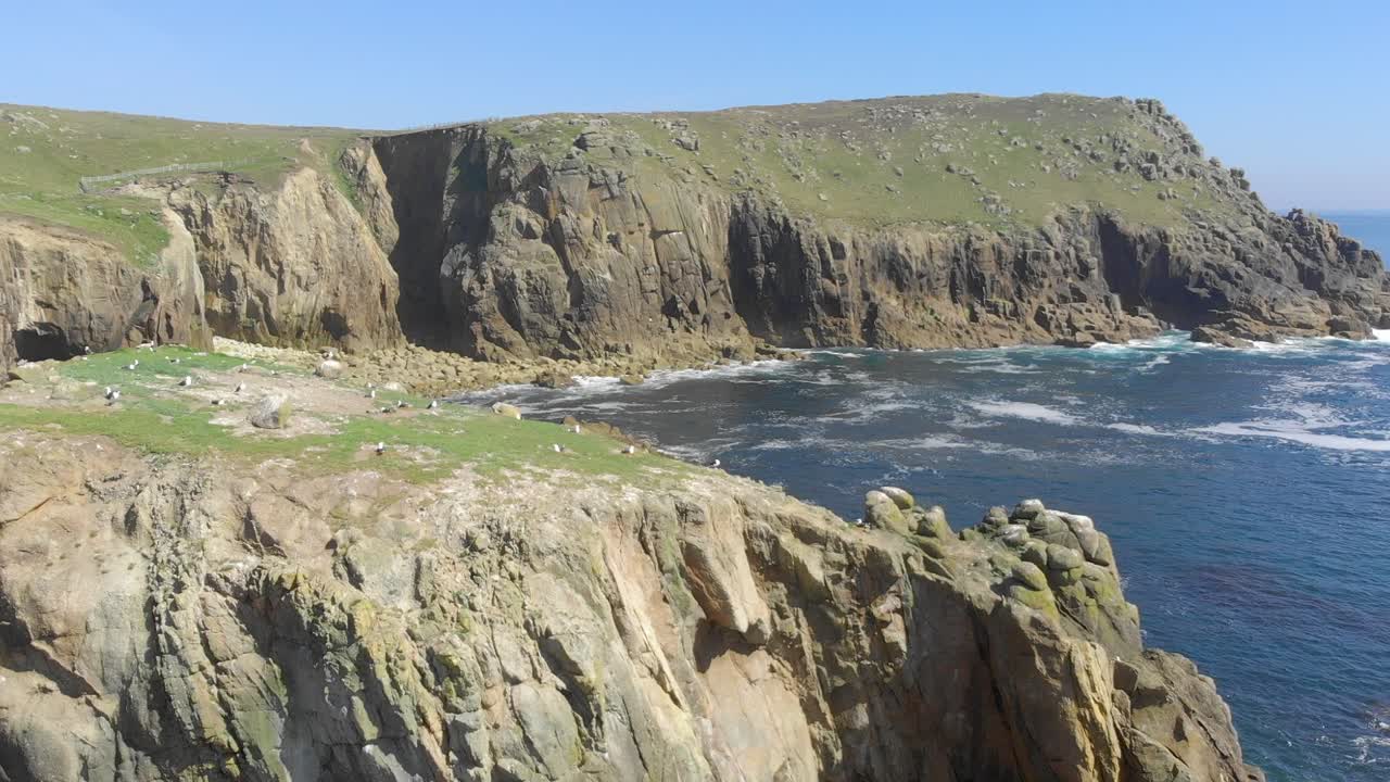Enys Dodnan Arch along the breathtaking stretch of coastline at Land's End, Cornwall during a warm sunny day