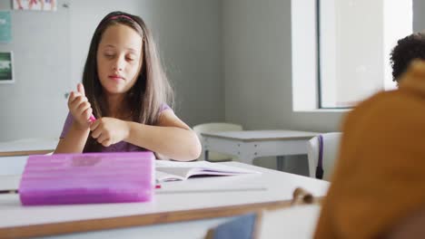 Video-Eines-Kaukasischen-Mädchens,-Das-Im-Klassenzimmer-Am-Schreibtisch-Sitzt