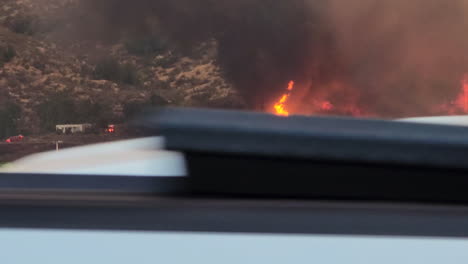 fairview wildfire, california usa, flames on hillside above vineyard, emergency lights, dark smoke and cars passing by