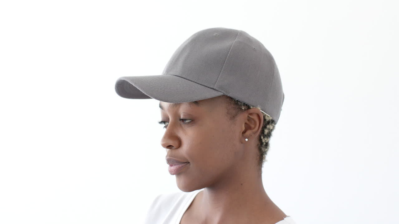 mujer afroamericana con gorra de pico gris con espacio de copia en fondo blanco