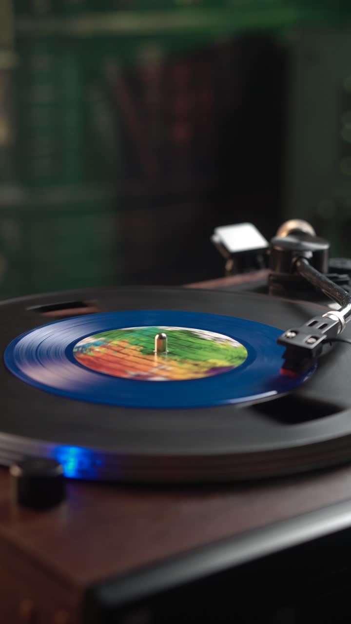 Vista verticale di un singolo disco in vinile blu su un giradischi vintage, primo piano