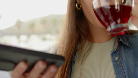 holding smartphone and drinking wine, woman relaxing at home spa day